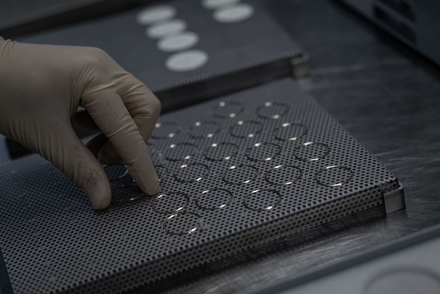 Rings of metal on a grey perforated sheet