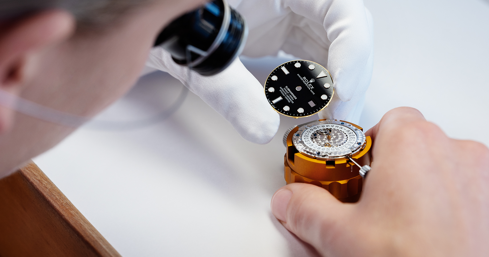 Black watch dial being placed on to a watch movement